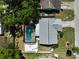 Aerial view showcases a home with a pristine pool, complemented by an outdoor firepit and verdant surroundings at 5611 22Nd E St, Bradenton, FL 34203
