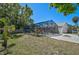 Backyard view features a pool with a screen enclosure, complimented by well-kept landscaping and a charming fire pit area at 5611 22Nd E St, Bradenton, FL 34203