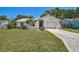 Charming single-story home with white exterior, lush lawn, palm trees and an attached one car garage at 5611 22Nd E St, Bradenton, FL 34203