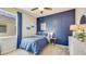 Cozy bedroom with natural light, blue accent wall, and patterned bedding at 5627 Silver Moonlight Dr, Palmetto, FL 34221