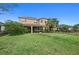 Large backyard features a screened-in porch, lush lawn, and mature palm trees providing shade at 5954 Anise Dr, Sarasota, FL 34238