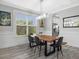 Bright dining room features a modern light fixture, wood table, and view to the yard at 5954 Anise Dr, Sarasota, FL 34238