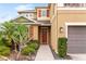 Tan two-story home with front yard landscaping and dark-stained wood front door with sidelight and decorative shutters at 5954 Anise Dr, Sarasota, FL 34238