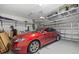 Attached two-car garage featuring overhead storage racks for organization and a red car at 5954 Anise Dr, Sarasota, FL 34238