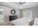 Serene main bedroom featuring a large round mirror, a ceiling fan, and a doorway to an ensuite bathroom at 5954 Anise Dr, Sarasota, FL 34238