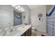 Well-lit bathroom featuring a large mirror, decorative nautical elements, and a shower with blue accents at 6105 114Th E Dr, Parrish, FL 34219