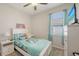 Bright bedroom with large window, white furniture, and mermaid-themed bedding, creating a playful space at 6105 114Th E Dr, Parrish, FL 34219