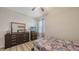 Well-lit bedroom with wood-look flooring, sports-themed bedding and a TV on a wooden dresser at 6105 114Th E Dr, Parrish, FL 34219