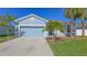 Charming one-story home with well-manicured landscaping, a two car garage, and a beautiful blue exterior at 6105 114Th E Dr, Parrish, FL 34219