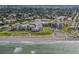 This aerial shows the community near the beach with mature trees, a pool, tennis courts, and ample parking at 700 Golden Beach Blvd # 222, Venice, FL 34285