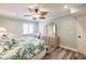 Comfortable bedroom with ceiling fan, wood-look floors, and light colors at 700 Golden Beach Blvd # 222, Venice, FL 34285