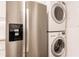Kitchen features stainless refrigerator, stacked washer/dryer in closet at 700 Golden Beach Blvd # 222, Venice, FL 34285