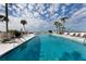 A stunning waterfront pool is surrounded by palm trees and plenty of lounge chairs at 700 Golden Beach Blvd # 222, Venice, FL 34285