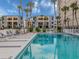 Pool with lush landscaping and lounge chairs in community with multiple buildings at 700 Golden Beach Blvd # 222, Venice, FL 34285