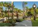 Picturesque street view lined with lush trees, tropical landscaping, and an antique clock at 700 Golden Beach Blvd # 222, Venice, FL 34285