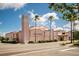 Venice Theater in pink, featuring the tall tower, set against a blue sky, with a wide open parking lot at 700 Golden Beach Blvd # 222, Venice, FL 34285