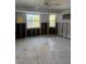 Bedroom featuring exposed studs, concrete floors, and natural light from two windows at 782 Birdsong Ln, Sarasota, FL 34242