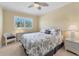 Cozy bedroom featuring a ceiling fan, a window and a white-framed bed with decorative bedding at 8106 Grand Estuary Trl # 102, Bradenton, FL 34212