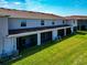 Rear exterior view of townhomes with screened lanais and green lawns at 8657 Milestone Dr, Sarasota, FL 34238