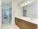 Bathroom with double sink vanity and a walk-in shower featuring glass doors at 10614 Morning Marsh Ln, Parrish, FL 34219