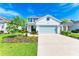 Well-kept home featuring a light blue garage door and meticulously landscaped front yard at 10614 Morning Marsh Ln, Parrish, FL 34219