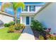 Inviting front entrance with a vibrant blue door and lush, colorful landscaping at 10614 Morning Marsh Ln, Parrish, FL 34219