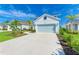 Charming home with a light blue garage door, beautifully landscaped yard, and inviting curb appeal at 10614 Morning Marsh Ln, Parrish, FL 34219