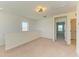 Upstairs loft area features carpet, white walls, a ceiling fan, and natural light from multiple windows at 10614 Morning Marsh Ln, Parrish, FL 34219