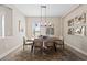 Bright dining room with modern chandelier, wooden table, and neutral tones at 12352 Auburndale Ct, Venice, FL 34293