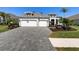 Charming home featuring a paver driveway, well-manicured lawn, and a two-car garage at 12352 Auburndale Ct, Venice, FL 34293