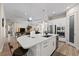Open-concept kitchen featuring quartz countertops, stainless appliances, island with barstools, and sleek white cabinetry at 12352 Auburndale Ct, Venice, FL 34293