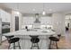 Modern white kitchen features a large island, stainless steel appliances, pendant lighting, and breakfast bar at 12352 Auburndale Ct, Venice, FL 34293