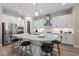 Bright kitchen featuring white cabinetry, stainless steel appliances, a large island, and pendant lighting at 12352 Auburndale Ct, Venice, FL 34293