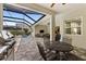 View of an outdoor kitchen and dining area on a lanai, plus a screened-in pool at 12352 Auburndale Ct, Venice, FL 34293