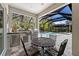Outdoor kitchen on the lanai featuring a built-in grill, sink, mini-fridge, and seating at 12352 Auburndale Ct, Venice, FL 34293
