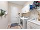 Well-organized laundry room with a front-load washer and dryer, cabinets for storage, and a utility sink at 12352 Auburndale Ct, Venice, FL 34293