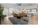 Open-concept living room with hardwood floors, stylish furniture, and seamless flow to kitchen and dining areas at 12352 Auburndale Ct, Venice, FL 34293