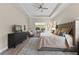 Comfortable main bedroom with a king-size bed, dresser, and a cozy seating area by the window at 12352 Auburndale Ct, Venice, FL 34293