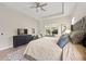 Relaxing main bedroom featuring a king bed, a TV on the dresser, and a large window for natural light at 12352 Auburndale Ct, Venice, FL 34293