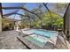 Screened in swimming pool and hot tub with brick pavers in tropical backyard at 12352 Auburndale Ct, Venice, FL 34293