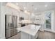 Modern white kitchen with stainless steel appliances, quartz countertops, and island at 12413 Gulf Breeze Ter, Cortez, FL 34215