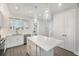 Modern white kitchen with stainless steel appliances, quartz countertops, and island at 12413 Gulf Breeze Ter, Cortez, FL 34215