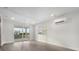 Bright living room with wood-look flooring, white ceiling, and access to outdoor balcony at 12413 Gulf Breeze Ter, Cortez, FL 34215