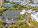 Aerial view of community tennis courts, swimming pool, and well-manicured landscaping at 1260 Dolphin Bay Way # 404, Sarasota, FL 34242