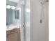 Bathroom with a modern white tiled shower and a vanity with great lighting and a decorative mirror at 1260 Dolphin Bay Way # 404, Sarasota, FL 34242