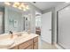Neutral bathroom features a framed mirror, vanity, and glass enclosed shower, connecting to another room at 1260 Dolphin Bay Way # 404, Sarasota, FL 34242