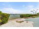 Secluded beach area with white sand, lush greenery, and a boat gliding across the clear water at 1260 Dolphin Bay Way # 404, Sarasota, FL 34242