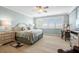 Bright bedroom featuring wood floors, a ceiling fan, shuttered windows, and comfortable furnishings at 1260 Dolphin Bay Way # 404, Sarasota, FL 34242