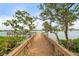 Scenic view of a wooden dock leading to calm waters, surrounded by lush greenery and blue skies at 1260 Dolphin Bay Way # 404, Sarasota, FL 34242