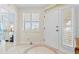 Bright foyer with white door, sidelights, shuttered window, and decorative tiled floor at 1260 Dolphin Bay Way # 404, Sarasota, FL 34242